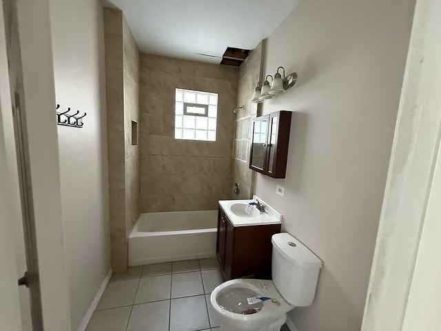 full bathroom with toilet, vanity, tile patterned flooring, and tiled shower / bath