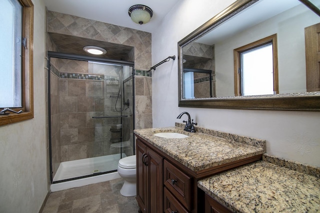 full bath with a stall shower, vanity, and toilet