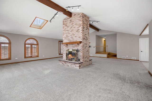 unfurnished living room with a fireplace, baseboards, beamed ceiling, and light colored carpet