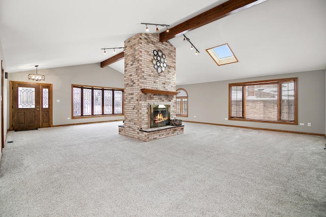 unfurnished living room with beamed ceiling, carpet, rail lighting, and baseboards