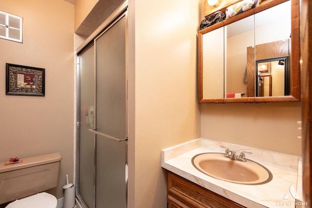 bathroom with toilet, vanity, and walk in shower