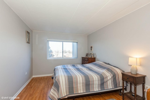 bedroom featuring baseboards and wood finished floors