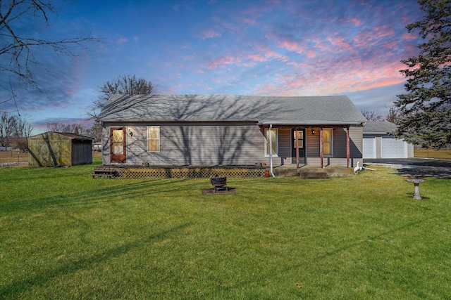 view of front of property with a garage, a front yard, covered porch, and an outdoor structure