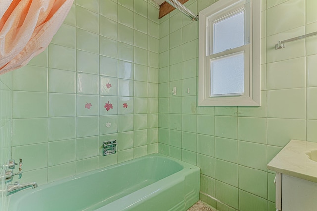 bathroom with a bathing tub, tile walls, and vanity