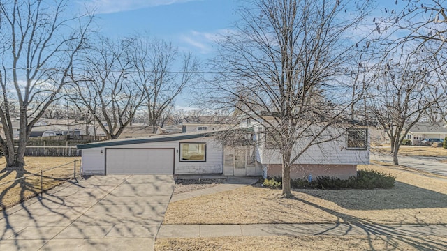 view of front of property with driveway, an attached garage, and fence