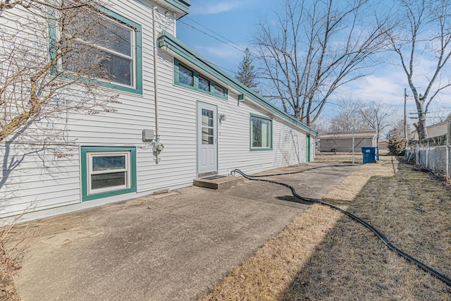 back of property featuring fence and a patio