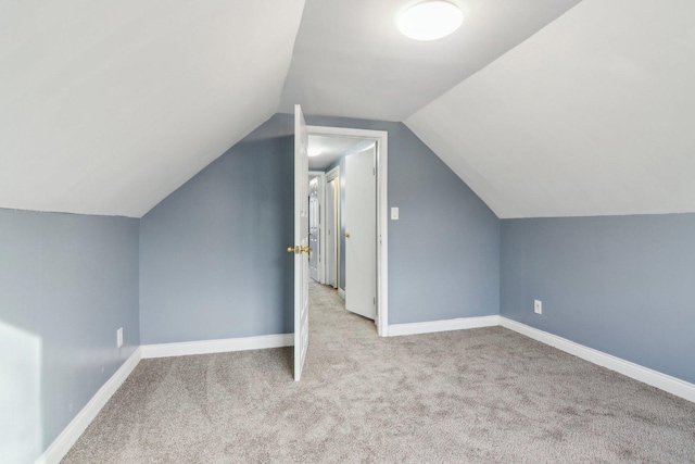 bonus room featuring lofted ceiling and light colored carpet