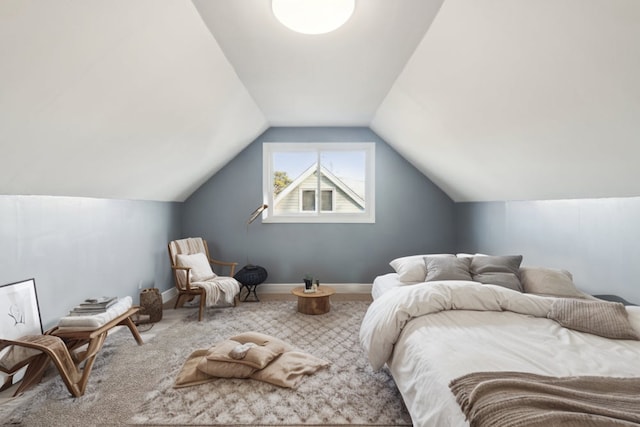 carpeted bedroom with lofted ceiling