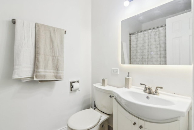 bathroom featuring a shower with shower curtain, vanity, and toilet