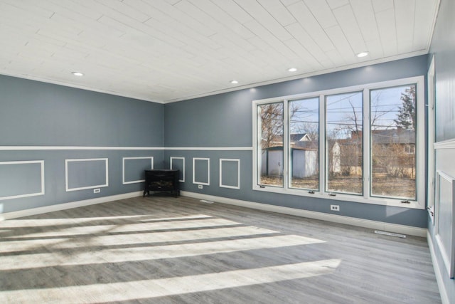 empty room featuring hardwood / wood-style floors and crown molding