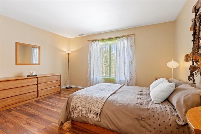 bedroom featuring dark wood finished floors, visible vents, and baseboards