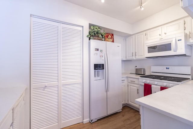 kitchen with light countertops, white appliances, and white cabinets