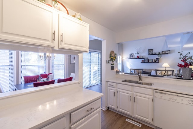 kitchen featuring light countertops, visible vents, white cabinets, a sink, and dishwasher