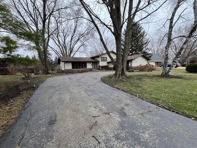 view of front of house featuring aphalt driveway and a front lawn