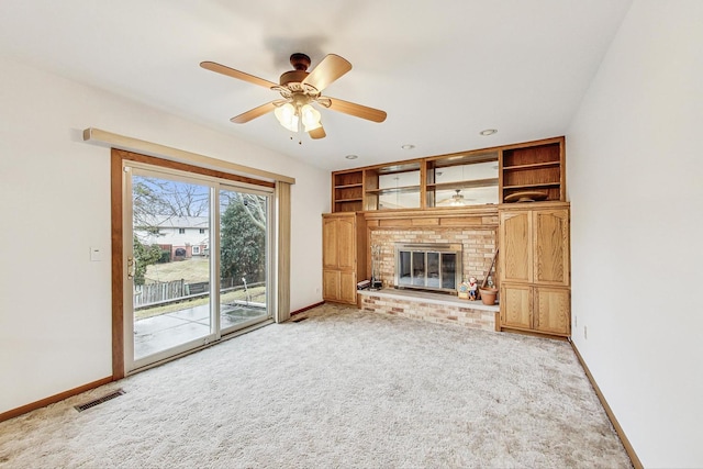 unfurnished living room with light carpet, a brick fireplace, baseboards, and visible vents