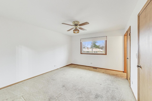 unfurnished bedroom featuring light carpet, a ceiling fan, and baseboards