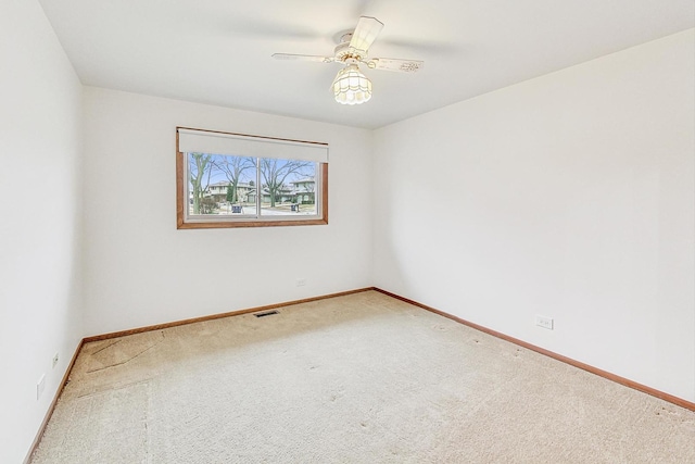 unfurnished room featuring carpet, visible vents, ceiling fan, and baseboards