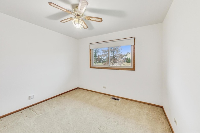 carpeted empty room with visible vents, ceiling fan, and baseboards