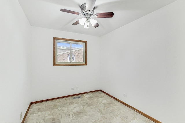 empty room with visible vents, a ceiling fan, and baseboards