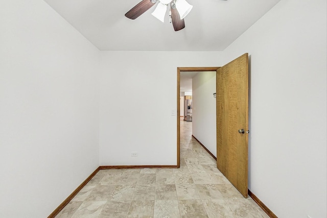 unfurnished room featuring a ceiling fan and baseboards