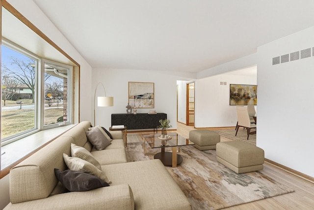 living area with visible vents, baseboards, and wood finished floors