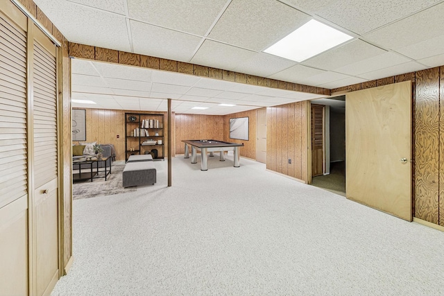 finished below grade area featuring carpet flooring, billiards, wood walls, and a drop ceiling