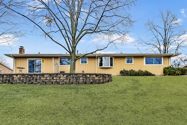 rear view of property with a lawn and a chimney