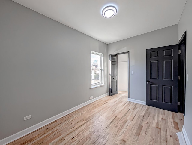 unfurnished bedroom with light wood-type flooring and a closet