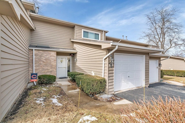 doorway to property with brick siding and an attached garage