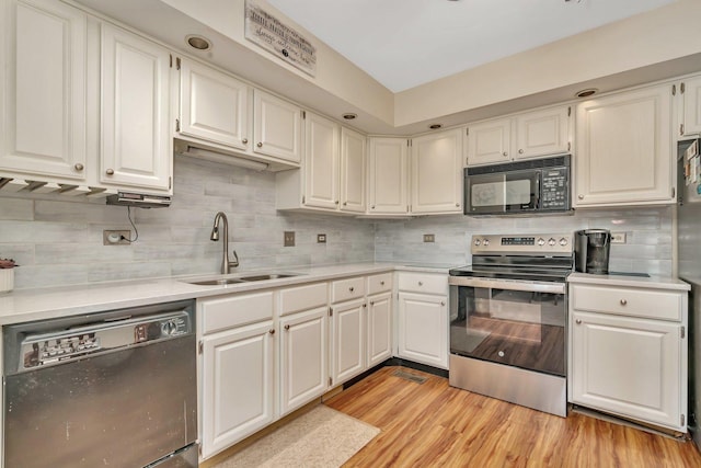 kitchen with dishwasher, light countertops, stainless steel range with electric cooktop, black microwave, and a sink