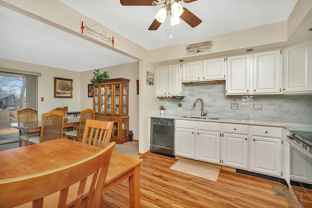 kitchen with a sink, black dishwasher, light countertops, electric range oven, and tasteful backsplash