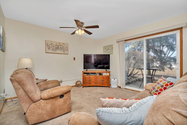 living area with ceiling fan, baseboards, and light colored carpet