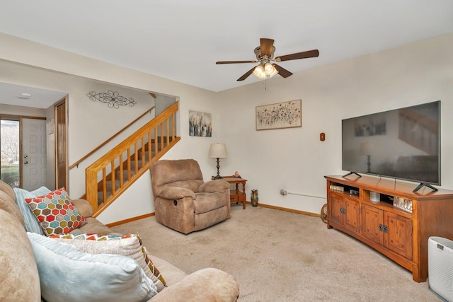 living area with a ceiling fan, light colored carpet, stairway, and baseboards