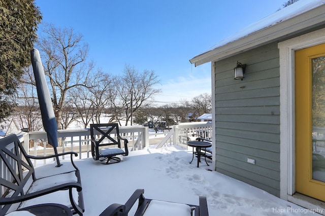 snow covered patio with a deck