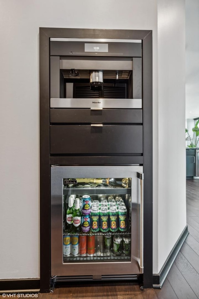 interior details with beverage cooler, baseboards, and wood finished floors