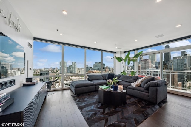 living room with visible vents, dark wood-type flooring, expansive windows, a view of city, and recessed lighting