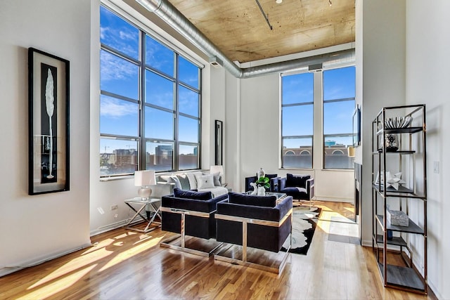 sitting room featuring light hardwood / wood-style floors and a towering ceiling