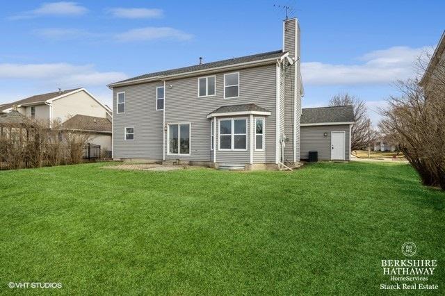 rear view of property featuring a patio area and a lawn