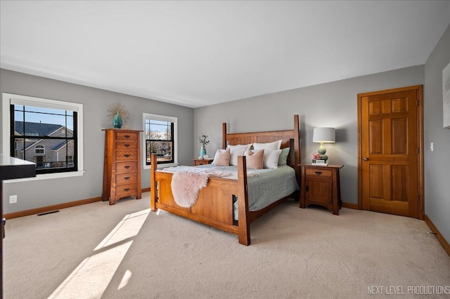 bedroom featuring light colored carpet, visible vents, and baseboards