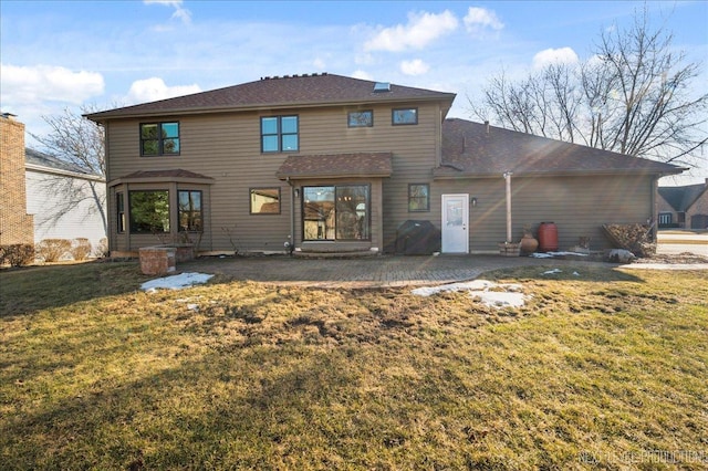 rear view of property featuring a patio and a lawn