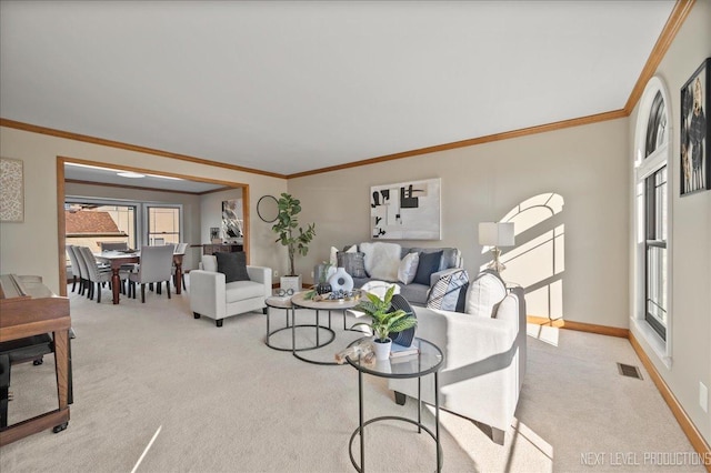 carpeted living area with baseboards, visible vents, and ornamental molding