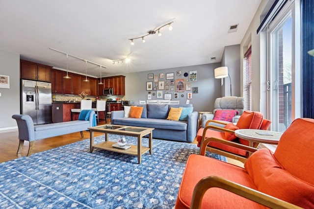 living room featuring baseboards, visible vents, and dark wood finished floors