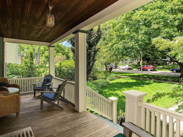 wooden terrace with a yard and a porch