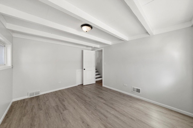 interior space featuring visible vents, beamed ceiling, baseboards, and wood finished floors