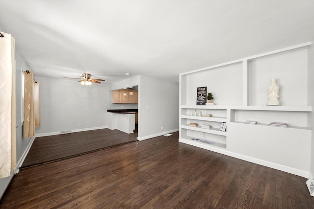 unfurnished living room featuring ceiling fan, baseboards, and dark wood-style flooring