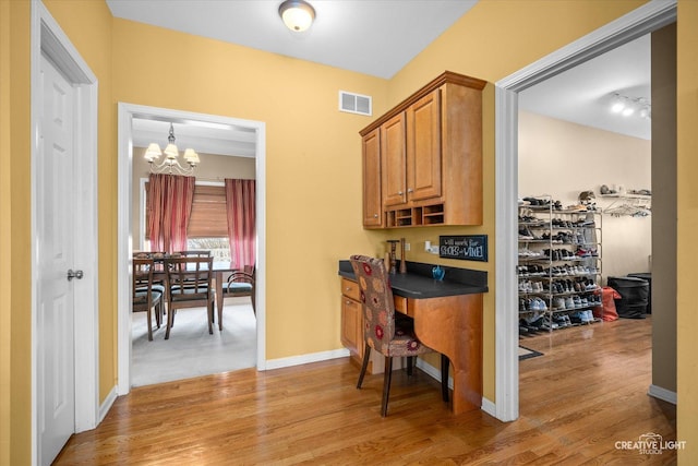 home office with light wood-style flooring, a notable chandelier, baseboards, and visible vents