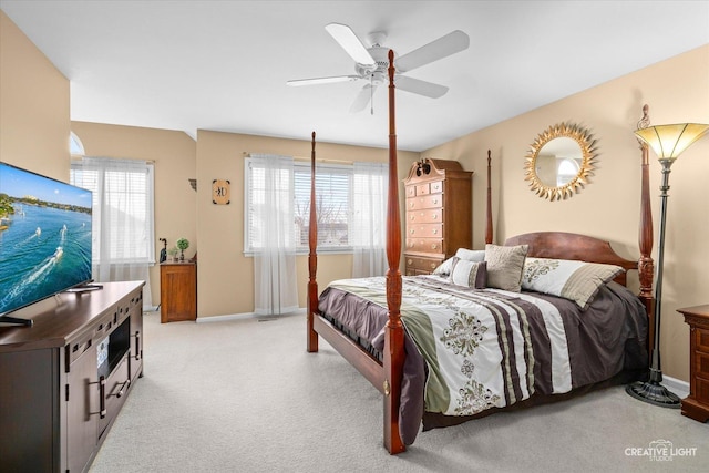 bedroom with light colored carpet, baseboards, and ceiling fan