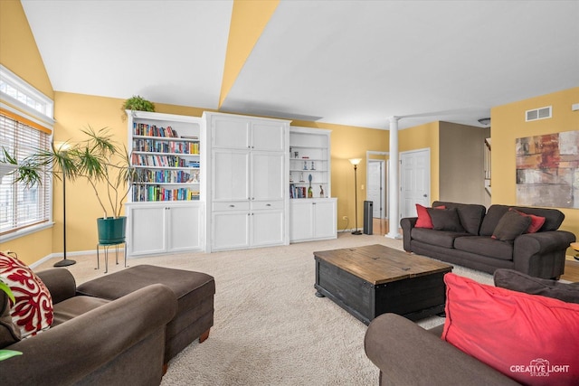 living area with visible vents, light carpet, baseboards, and decorative columns