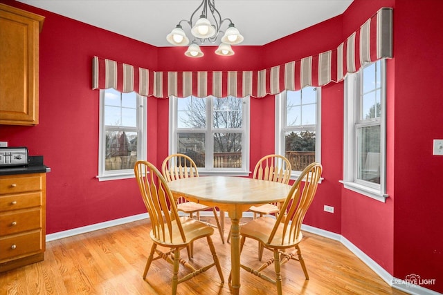 dining space with a chandelier, plenty of natural light, and light wood-style flooring