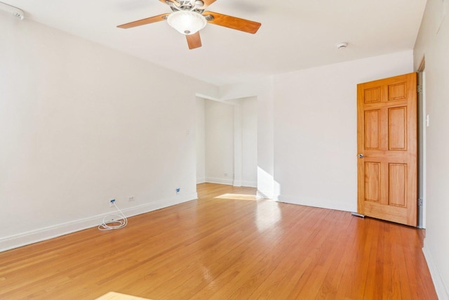 unfurnished room featuring baseboards, ceiling fan, and light wood-style floors